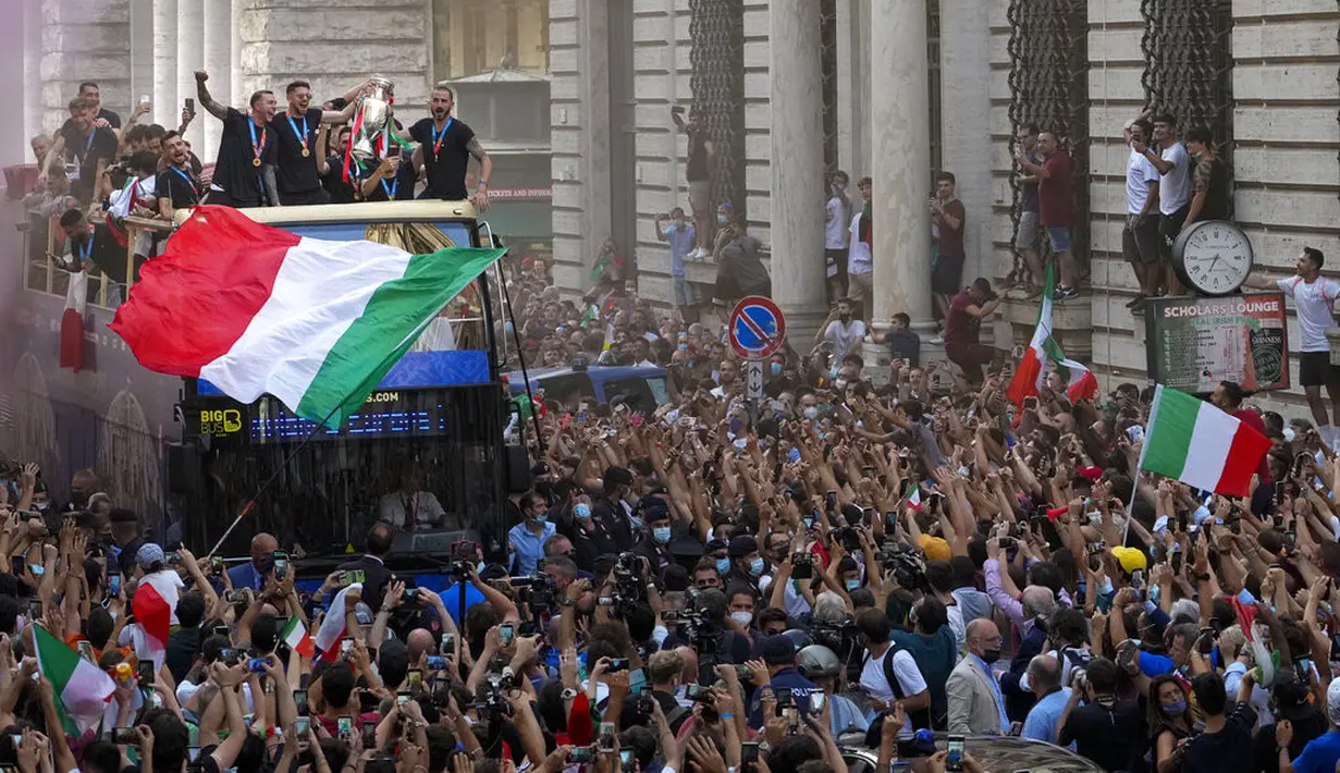Para pemain Italia berada di atas bus saat perayaan juara Euro 2020 di Roma, Senin (12/7/2021). Italia mengalahkan Inggris 3-2 dalam adu penalti setelah bermain imbang 1-1 pada final Euro 2020 di stadion Wembley di London. (AP Photo/Gregorio Borgia)