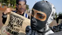 Sekelompok masyarakat mengenakan topeng wajah Salim Kancil saat menggelar aksi di depan Istana Negara, Jakarta, Kamis (1/10/2015). Dalam aksinya mereka menuntut keadilan bagi Salim Kancil dan Tosan. (Liputan6.com/Gempur M Surya)