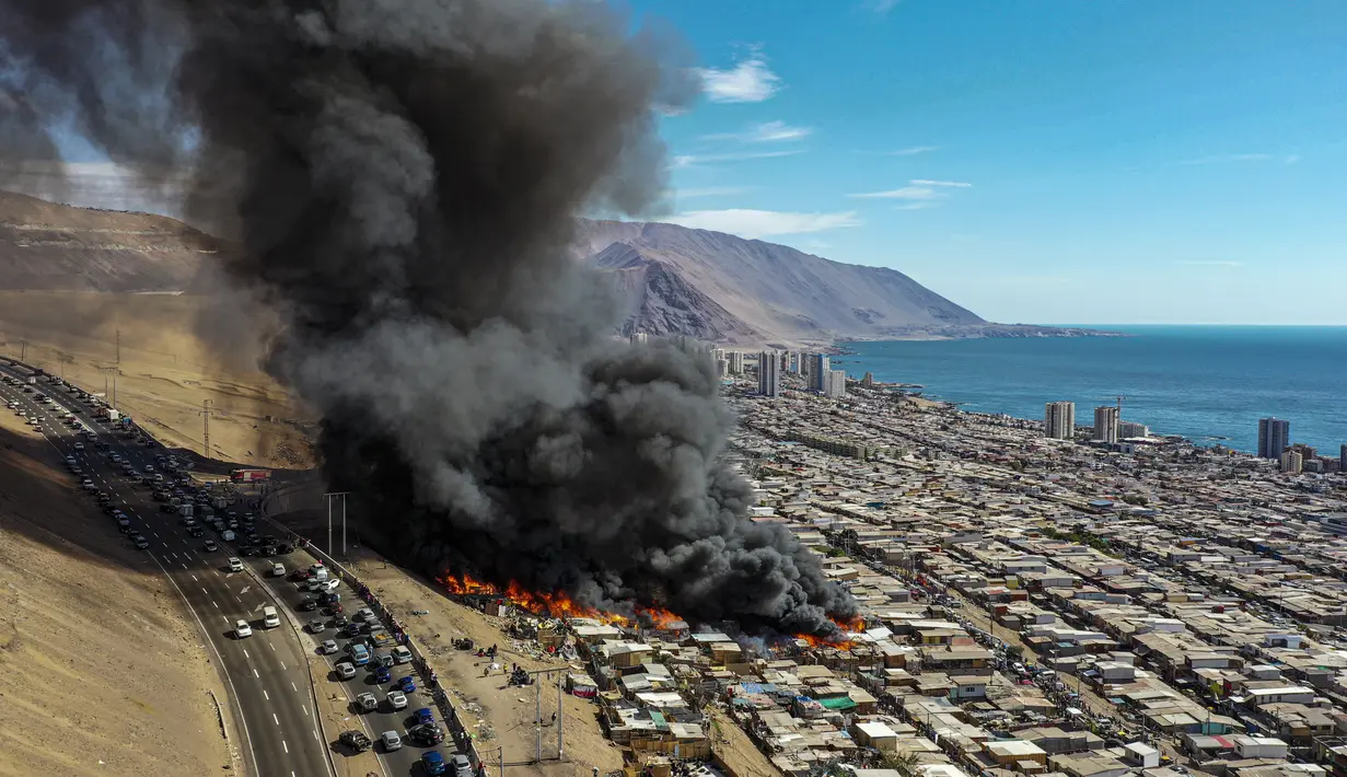 Rumah-rumah terbakar selama kebakaran di lingkungan berpenghasilan rendah Laguna Verde, di Iquique, Chile, Senin (10/1/2022). Menurut pihak berwenang, api menghanguskan hampir 100 rumah di lingkungan itu yang sebagian besar dihuni oleh para migran. (AP Photo/Ignacio Munoz)