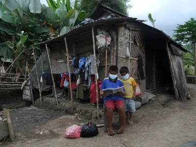 Dua anak membaca buku di depan sebuah rumah di kawasan Sidemen, Karangasem, Bali, Kamis (2/9/2021). Badan Pusat Statistik Provinsi Bali mengumumkan penduduk miskin Bali kini berjumlah 201.970 orang dari sekitar 4,32 juta orang penduduk Bali. (merdeka.com/Arie Basuki)