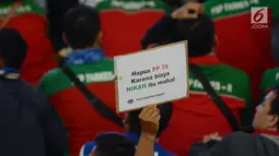 Massa buruh mengangkat poster bertuliskan tuntutan dalam aksi peringatan Hari Buruh 2019 di Tenis Indoor Senayan, Jakarta, Rabu (1/5/2019). Aksi peringatan May Day yang digelar KSPI itu untuk menyuarakan kesejahteraan buruh serta demokrasi jujur dan damai. (merdeka.com/Imam Buhori)