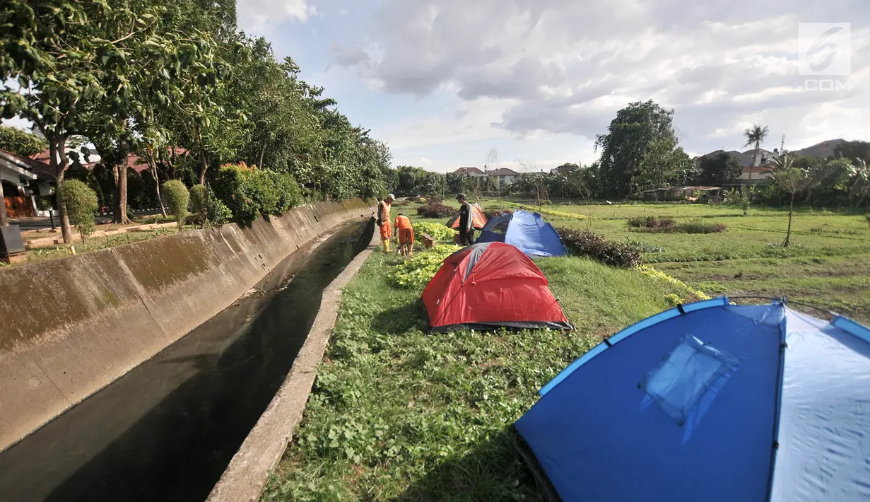Petugas Penanganan Prasarana dan Sarana Umum (PPSU) mendirikan tenda saat persiapan untuk doa bersama pada malam Tahun Baru di Cipinang Melayu, Jakarta, Minggu (30/12). (Merdeka.com/ Iqbal S. Nugroho)
