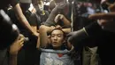 Para pengunjuk rasa mengikat seorang pria yang mengenakan kaus bertuliskan kata-kata "Saya suka polisi" yang menurut para pengunjuk rasa adalah seorang petugas polisi dari China daratan, saat demonstrasi di Bandara di Hong Kong (13/8/2019). (AP Photo/Vincent Yu)