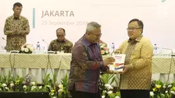 Ketua KPU Arief Budiman memberikan cenderamata kepada Menteri PPN/Bappenas Bambang Brodjonegoro saat Penyampaian Rancangan Teknokratik RPJMN 2020-2025 di Gedung KPU, Jakarta, Selasa (25/9). (Liputan6.com/Herman Zakharia)