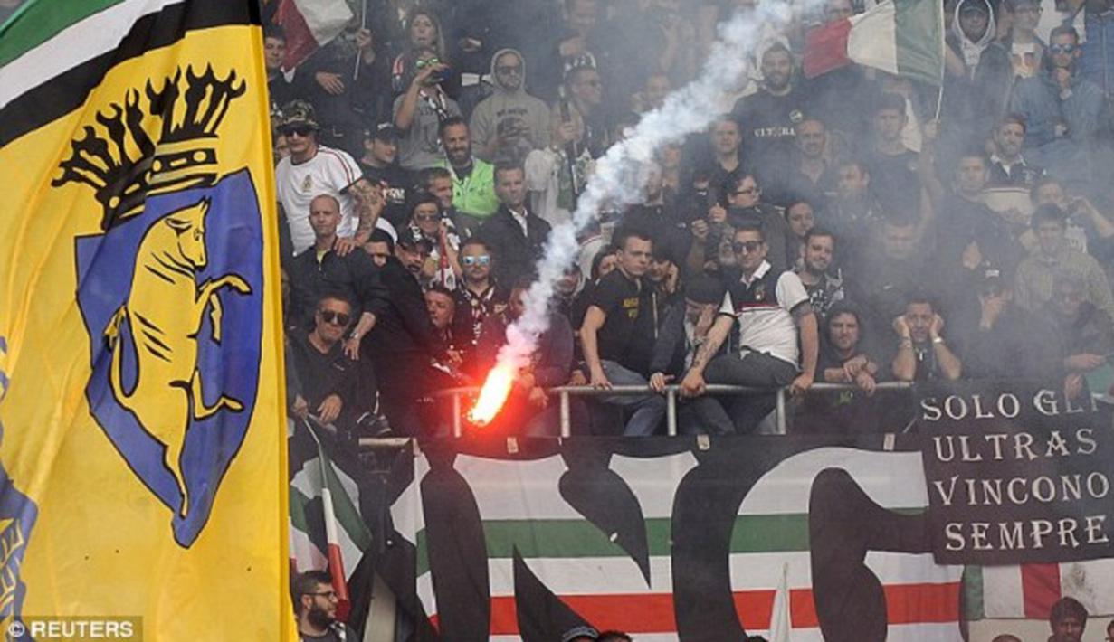 Sebuah suar menyala di stadion di mana sembilan penggemar dilaporkan terluka selama derby. (Dailymail)