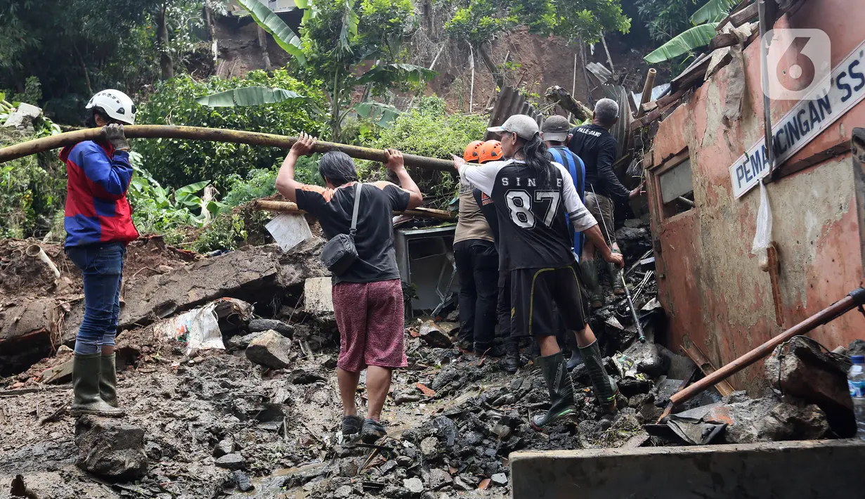 Petugas membersihkan material longsor pada areal pemancingan yang menyebabkan satu orang meninggal dunia di Gang Kepatihan, Kelurahan Kebon Kelapa, Kecamatan Bogor Tengah, Bogor, Jawa Barat, Rabu (12/10/2022). Longsor yang terjadi pada kemarin sore menyebabkan sembilan pemancing tertimbun tanah namun selamat dan seorang anggota kepolisian meninggal. (merdeka.com/Arie Basuki)
