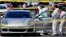 Tim forensik melakukan olah tempat kejadian perkara penembakan pengendara mobil sport Porsche oleh orang tidak dikenal di Guadalajara, Meksiko, (14/3). Pihak berwenang mencatat 25.339 pembunuhan pada tahun 2017. (AFP Photo/Ulises Ruiz)