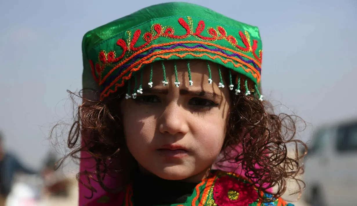 Khatera (4) berpose selama perayaan Nowruz, Tahun Baru Persia, di Kabul, Afghanistan, (21/3). Nowruz dirayakan pada hari pertama musim semi di negara-negara termasuk Afghanistan, Tajikistan, dan Iran. (AP Photo/Rahmat Gul)