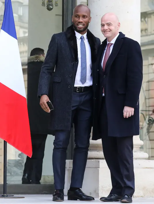 Mantan penyerang Pantai Gading, Didier Drogba berpose bersama Presiden FIFA Gianni Infantino saat tiba di Istana Elysee di Paris, (21/2). Didier Drogba diundang makan siang Presiden Prancis dan Presiden Liberia. (AFP Photo/Ludovic Marin)