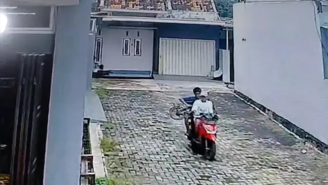 Tangkapan layar rekaman kamera CCTV saat dua maling sepeda senyum sumringah.