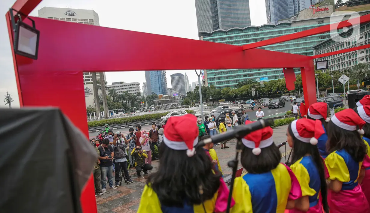 Warga menyaksikan grup vokal bernyanyi dalam acara Christmas Carol di Kawasan Bundaran HI, Jakarta, Kamis (22/12/2022). Pemerintah provinsi (Pemprov) DKI Jakarta kembali mengadakan Christmas Carol untuk merayakan Natal di Ibu Kota. Pagelaran ini diadakan mulai Rabu (21/12) hingga Jumat (23/12) dari pukul 15.30-17.30 WIB yang diselenggarakan di tiga titik, seperti Terowongan Kendal, kawasan Bundaran HI, dan Kota Tua. (Liputan6.com/Faizal Fanani)
