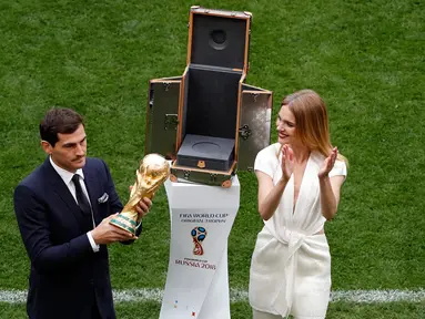 Mantan kiper timnas Spanyol, Iker Casillas didampingi supermodel Rusia,  Natalia Vodianova memamerkan trofi Piala Dunia 2018 sebelum laga pembuka di stadion Luzhniki, Moskow, Kamis (14/6). Trofi Piala Dunia itu terbuat dari emas 18 karat (AP/Darko Bandic)