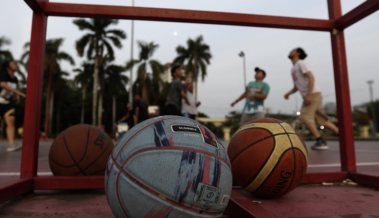 Sejumlah warga bermain basket di kawasan Monas, Jakarta, Jumat (11/10). Kawasan Monas menjadi pilihan warga Jakarta dan pekerja ibu kota untuk berolahraga sore. (Bola.com/Yoppy Renato)