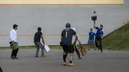 Sejumlah pria bermain "pelota nacional" atau bola nasional di Quito, Ekuador (24/7). Permainan ini sudah dimainkan sejak abad ke-14 oleh masyarakat adat yang mendiami perbatasan Kolombia dan Ekuador. (AFP Photo/Juan Cevallos)