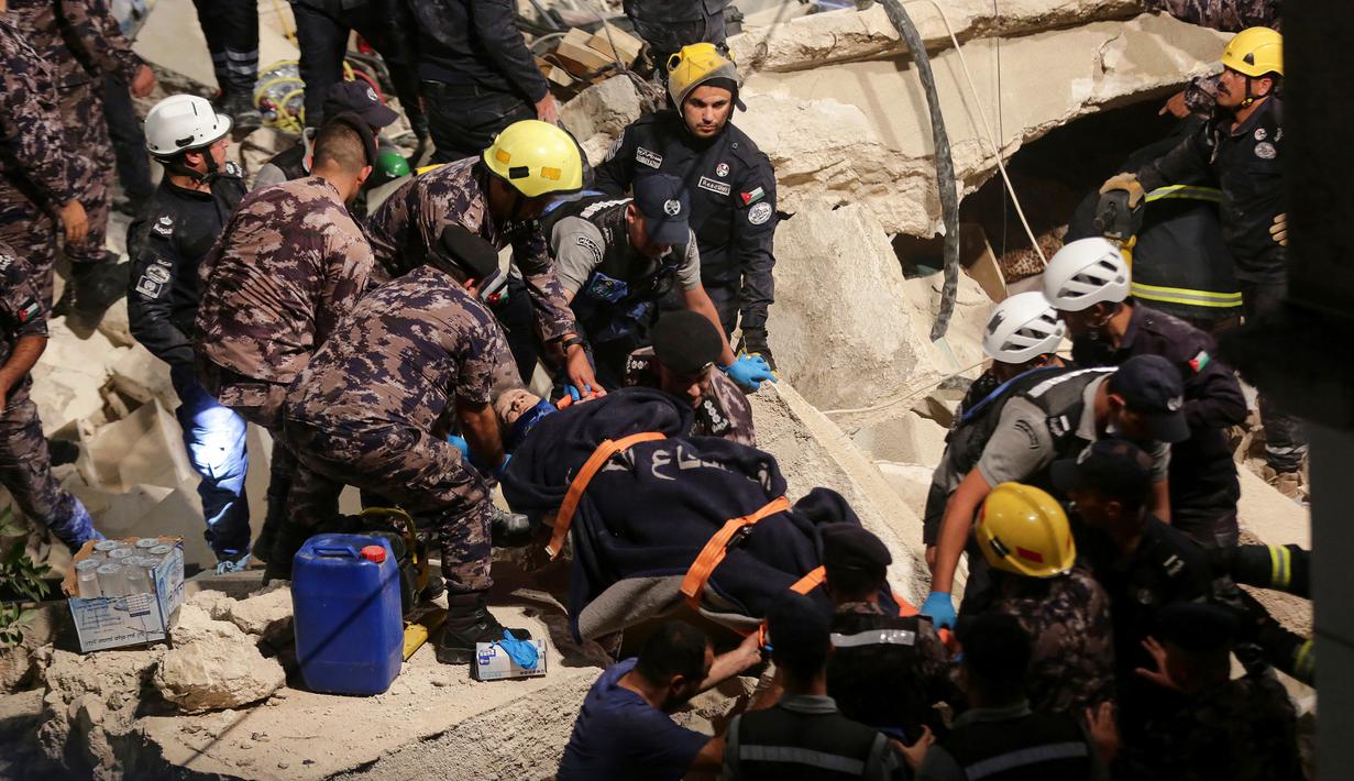 Tim penyelamat dari Pertahanan Sipil Yordania membawa seorang korban yang merupakan penghuni bangunan yang runtuh, di Amman, Yordania, Selasa (13/9/2022). Dalam insiden ini menyebabkan sedikitnya lima tewas dan tujuh lainnya terluka. (AP Photo/Raad Adayleh)