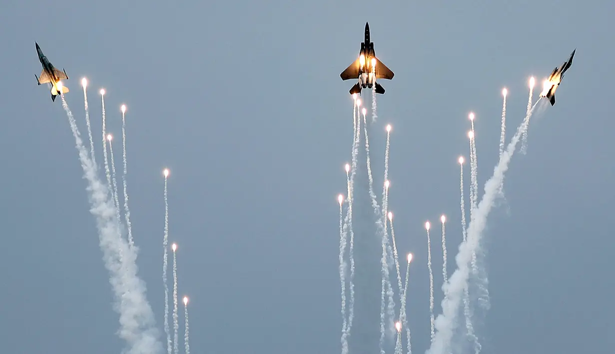 Jet tempur F-15SG (tengah) di antara dua jet tempur F-16 dari Angkatan Udara Republik Singapura bermanuver di udara jelang Singapore Airshow 2018, Jumat (2/2). Singapore Airshow 2018 dihelat setiap dua tahun. (AP Photo/Wong Maye-E)