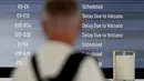 Salah satu calon penumpang melihat papan elektronik yang menampilkan penerbangan yang dibatalkan di Bandara Internasional Ngurah Rai, Tuban, dekat Denpasar, Bali, pada 21 Maret 2025. (SONNY TUMBELAKA/AFP)