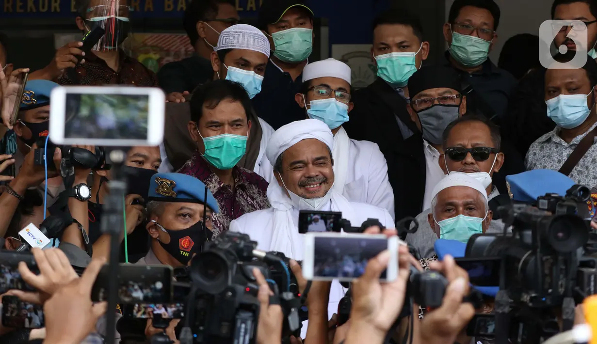 Rizieq Shihab (tengah) memberi keterangan sesaat sebelum masuk gedung utama Mapolda Metro Jaya, Jakarta, Sabtu (12/12/2020). Rizieq Shihab akan menjalani pemeriksan sebagai tersangka penghasutan dan kerumunan di tengah pandemi Covid-19. (Liputan6.com/Helmi Fithriansyah)