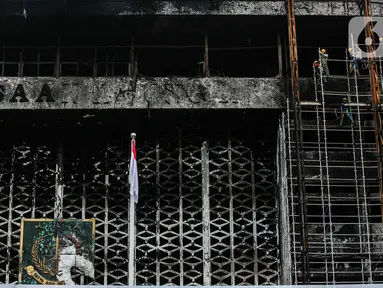 Pekerja memasang 'scaffolding' atau struktur besi untuk melakukan perbaikan Gedung Kejaksaan Agung, Jakarta, yang hangus terbakar, Rabu (7/10/2020).  Kebakaran pada 22 Agustus 2020 lalu mengakibatkan kerusakan berat pada seluruh bangunan Gedung Utama Kejaksaan Agung. (Liputan6.com/Faizal Fanani)