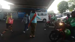 Polwan Polres Jakarta Timur mengenakan kebaya ketika membantu pejalan kaki menyeberang lintas di Jalan Otista Raya, Jatinegara, Jumat (20/4). Para polwan itu berkebaya dalam mengatur lalu lintas untuk memperingati Hari Kartini. (Merdeka.com/Imam Buhori)