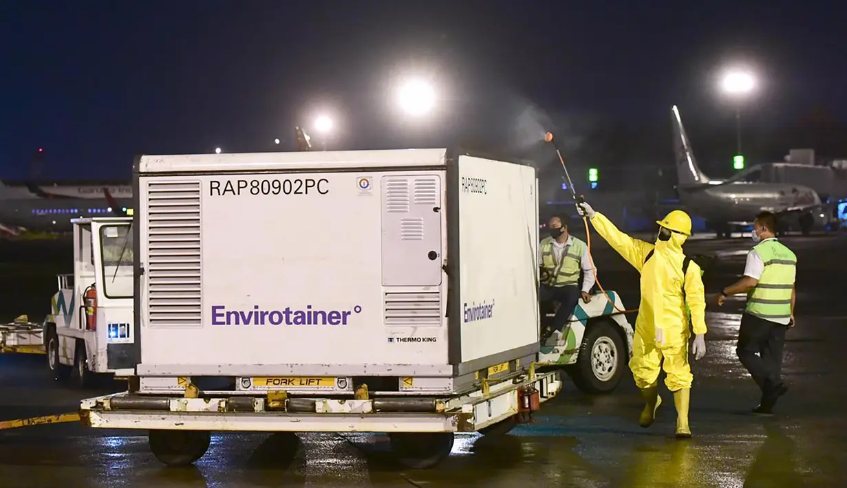 Petugas menyemprotkan disinfektan ke vaksin Covid-19  Sinovac saat tiba di Bandara Soekarno Hatta Cengkareng, Banten (6/12/2020). Vaksin tersebut dalam bentuk jadi atau siap pakai buatan Sinovac, perusahaan biomedis asal China. (Handout/Indonesia Presidential Palace/AFP)