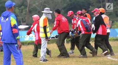 Petugas mengevakuasi atlet paralayang putri asal Malaysia Sharifah Nadiah Wafa saat bertanding pada nomor ketepatan mendarat Asian Games 2018, Bogor (21/8). Sharifah diduga mengalami cedera bagian pinggul kaki kanan ke bawah. (Merdeka.com/Arie Basuki)