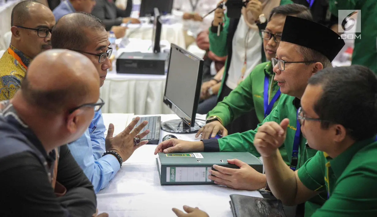 Sekjen PPP kubu Romahurmuziy (Romi) Arsul Sani berbincang dengan anggota Komisioner KPU, Hasyim Ashari di Kantor KPU RI, Jakarta, Sabtu (14/10). PPP kubu Romi secara resmi mendaftar sebagai peserta pemilihan umum 2019. (Liputan6.com/Faizal Fanani)