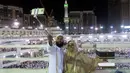 Dua umat Muslim berfoto dengan latar belakang Kabah saat melaksanakan ibadah haji di Masjidil Haram, Mekah, Minggu (4/9). Kepadatan semakin terlihat jelas di Masjidil Haram jelang pelaksanaan Haji 2016. (REUTERS/Ahmed Jadallah)