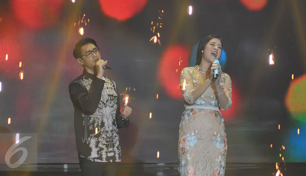 Raisa dan Afgansyah Reza saat berduet menyanyikan single terbaru mereka berjudul "Percayalah" dalam konser The Biggest Concert Jatuh Hati Raisa yang digelar di Studio 6 Emtek, Jakarta, Kamis (5/11) malam. (Liputan6.com/Herman Zakharia)