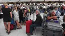 Penumpang berada di area check-in di Bandara Internasional Suvarnabhumi di Bangkok (28/2). Puluhan penerbangan menuju Eropa dibatalkan setelah Pakistan menutup wilayah udaranya karena ketegangan dengan India meningkat. (AFP Photo/Lillian Suwnrumpha)