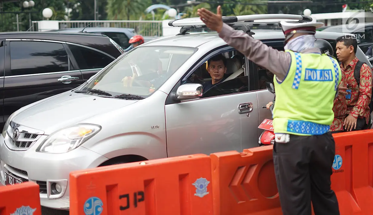 Polisi memberi arahan pada pengendara di sekitar lokasi pengalihan arus lalu lintas di Jalan Medan Merdeka Timur, Jakarta, Jumat (14/6/2019). Pengalihan arus dilakukan di sejumlah titik menuju Gedung Mahkamah Konstitusi terkait sidang sengketa Pilpres 2019. (Liputan6.com/Immanuel Antonius)