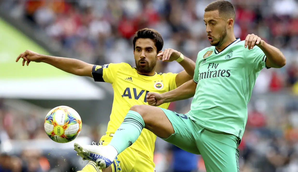 Gelandang Real Madrid, Eden Hazard berebut bola dengan pemain Fenerbache, Alper Potuk selama pertandingan Audi Cup 2019 di stadion Allianz Arena di Munich, Jerman (31/7/2019). Madrid menang atas Fenerbache dengan skor 5-3. (AP Photo/Matthias Schrader)
