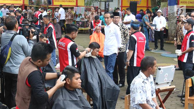 Presiden Joko Widodo didampingi Gubernur Jawa Barat Ridwan Kamil melihat warga mengikuti acara cukur rambut massal di Garut, Jawa Barat, Sabtu (19/1). (Liputan6.com/Angga Yuniar)