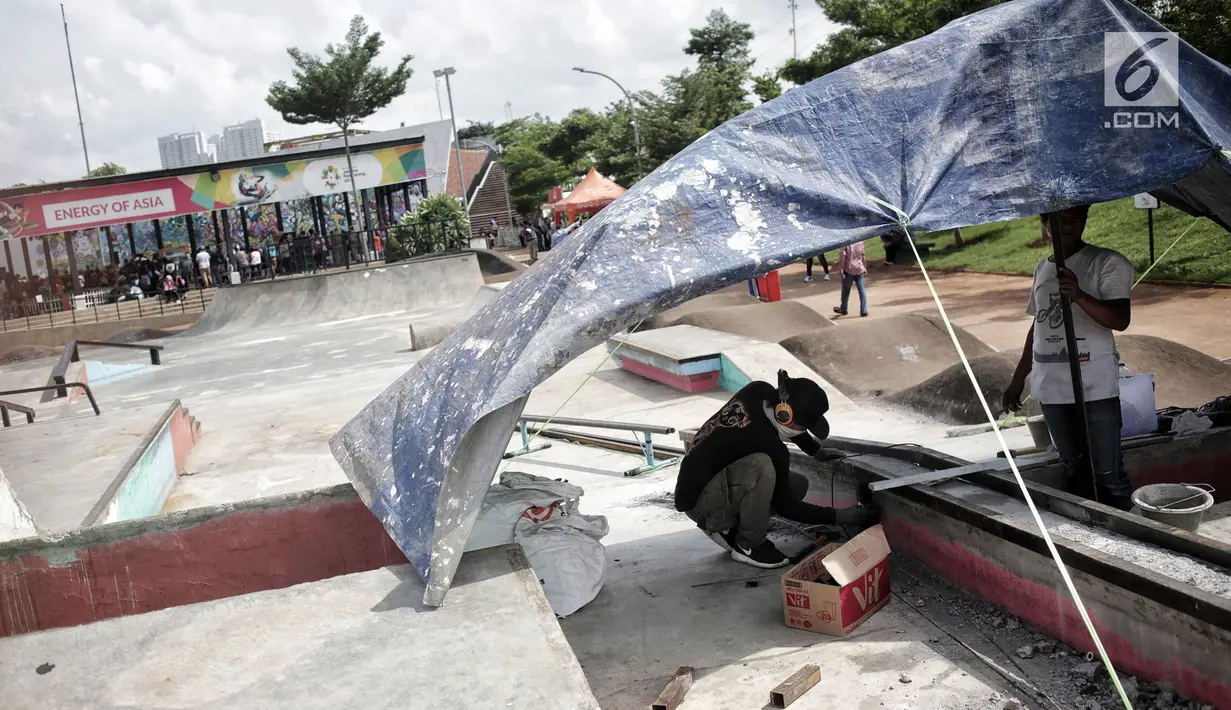 Pekerja memperbaiki arena skateboard yang rusak di RPTRA Kalijodo, Jakarta, Kamis (24/1). Perbaikan dilakukan untuk membuat rasa aman dan nyaman pengunjung yang menggunakan arena tersebut. (Liputan6.com/Faizal Fanani)
