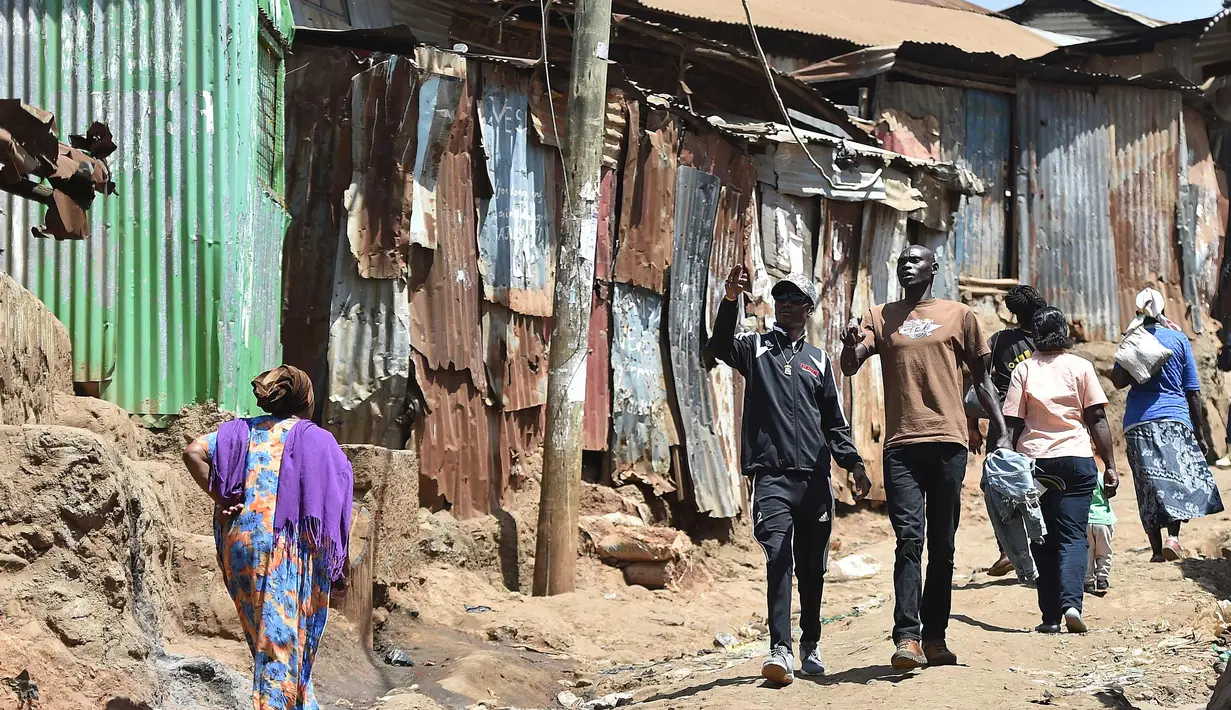 Henry Ohanga alias Octopizzo (tengah) berjalan dengan seorang teman saat berkunjung ke Kibera di Nairobi, Kenya (16/1). Seperti kebanyakan anak muda di daerah kumuh ini, Octopizzo berpikir dia tidak akan pernah menjadi apa-apa. (AFP Photo/Tony Karumba)