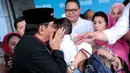 Baru keluar, ia langsung mengambil alih cucunya yang digendong oleh istrinya, Ida Laksmiwati yang mengenakan baju dan krudung merah. (Adrian Putra/Bintang.com)