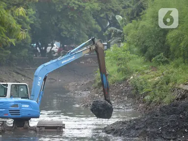 Pekerja mengoperasikan alat berat excavator untuk mengangkat material endapan lumpur di kanal sungai perkantoran Kuningan Jakarta, Rabu (17/2/2021). Pengerukan dilakukan untuk memperlancar aliran air agar tidak terjadi pendangkalan yang mengakibatkan genangan air. (merdeka.com/Imam Buhori)