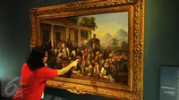 Pengunjung memperhatikan lukisan karya Raden Saleh berjudul Penangkapan Pangeran Diponegoro tahun 1857 yang dipamerkan di Galeri Nasional, Jakarta, Senin (1/8). (Liputan6.com/Gempur M Surya)