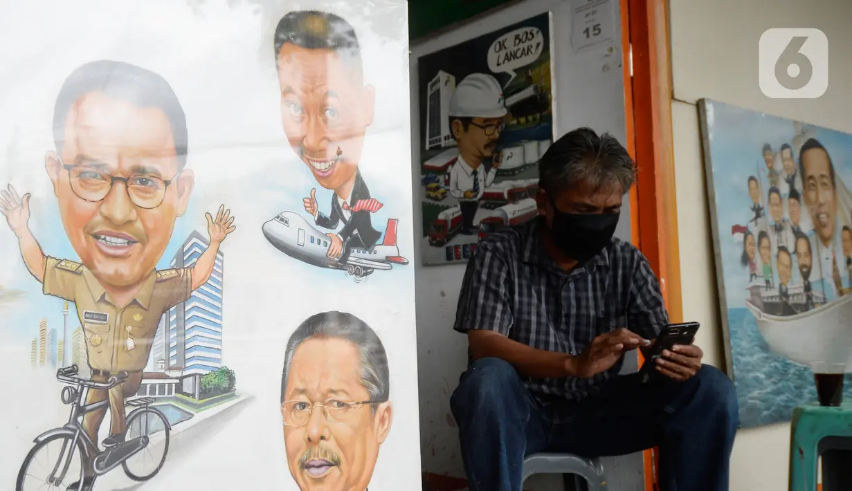 Seorang pelukis bermain ponsel di samping lukisan tokoh-tokoh nasional di Depan Pasar Baru, Jakarta, Kamis (24/12/2020). Para pelukis memasarkan lukisannnya dengan harga bervariasi dari dari Rp 500 ribu hingga Rp 2,5 juta. (merdeka.com/Dwi Narwoko)