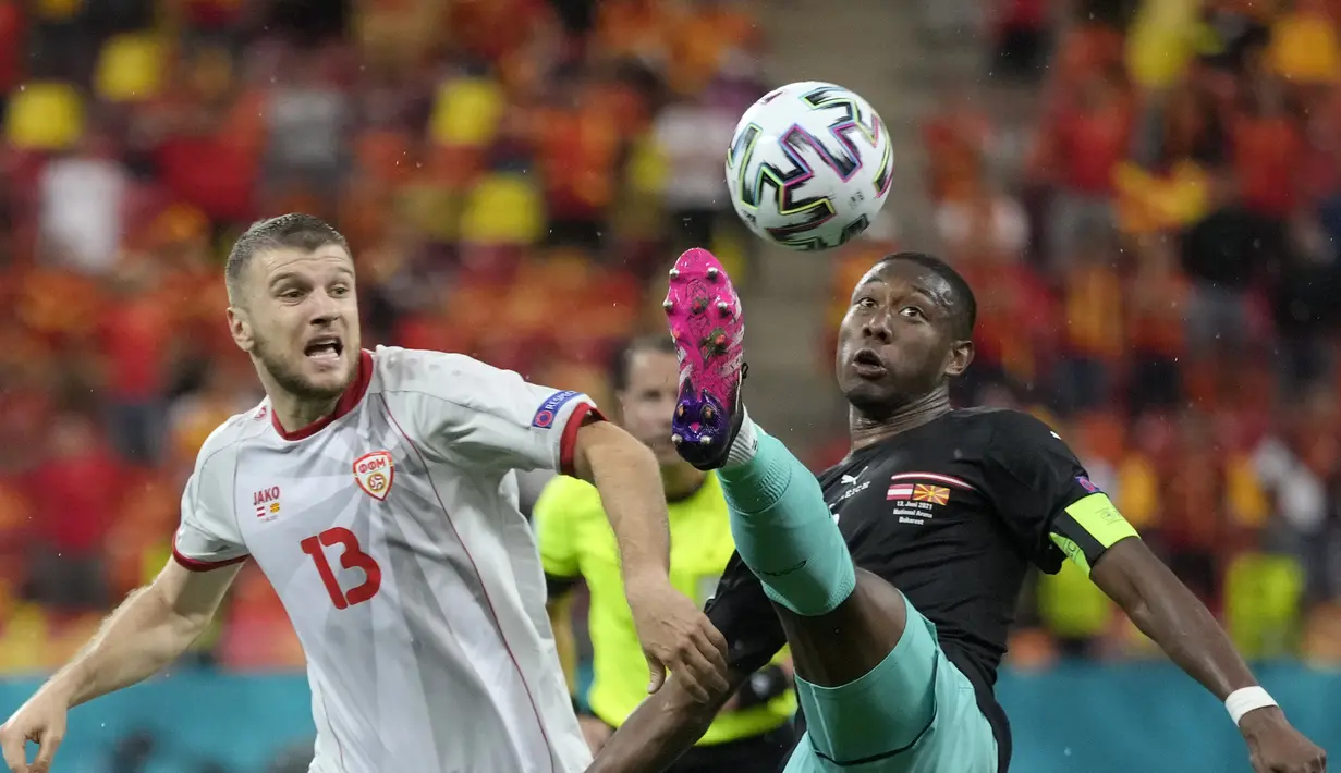 Bek Austria, David Alaba (kanan) berebut bola dengan pemain Makedonia Utara, Stefan Ristovski pada pertandingan grup C Euro 2020 di stadion National Arena di Bucharest, Rumania, Minggu (13/6/2021). Austria menang atas Makedonia Utara dengan skor 3-1. (AP Photo/Vadim Ghirda, Pool)