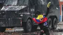 Seorang pengunjuk rasa anti-pemerintah melemparkan sekantong cat ke kendaraan polisi selama bentrokan di Madrid, di pinggiran Bogota, Kolombia (28/5/2021). (AP Photo/Ivan Valencia)