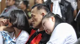 Aktor Tio Pakusadewo merangkul sang anak, Risa (kiri) dan keponakannya, Namira saat menunggu sidang  kasus penyalahgunaan narkoba di Pengadilan Negeri Jakarta Selatan, Kamis (28/6). Sidang beragenda pembacaan pledoi oleh Tio. (Liputan6.com/Faizal Fanani)