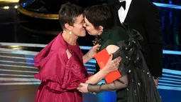 Frances McDormand memberikan penghargaan kepada Olivia Colman di atas panggung Oscar 2019 di Los Angeles, Minggu (24/2). Olivia Colman meraih piala Oscar 2019 sebagai Aktris Pemeran Utama Terbaik di film The Favourite. (Kevin Winter/Getty Images/AFP)
