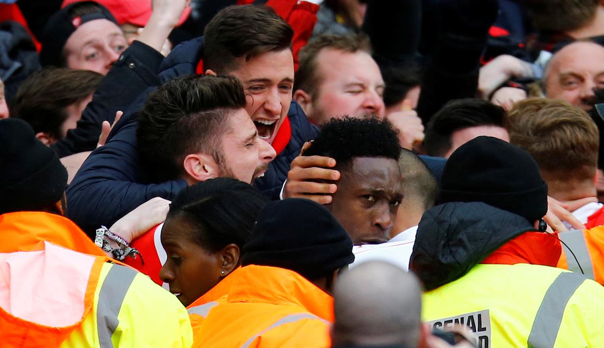 Striker Arsenal, Danny Welbeck, disambut rekan-rekannya setelah mencetak gol ke gawang Leicester City di menit akhir dalam laga Liga Inggris di Stadion Emirates, London, Minggu (14/2/2016). (Reuters/Darren Staples)
