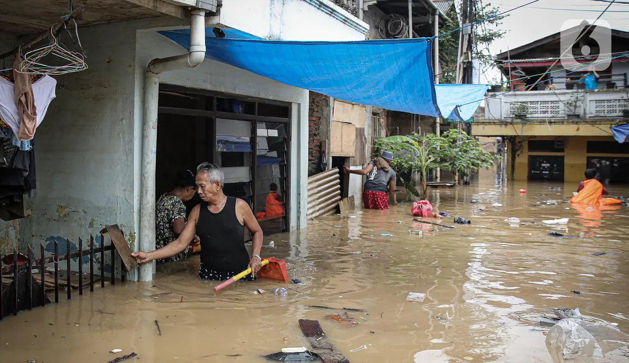 Warga dengan alat seadanya membersihkan rumah yang terendam banjir di kawasan Rawajati, Kalibata, Jakarta, Senin (10/10/2022). Tingginya curah hujan di kawasan Bogor mengakibatkan ratusan rumah di enam RT Kelurahan Rawajati terendam banjir dengan ketinggian mencapai dua meter. (Liputan6.com/Faizal Fanani)