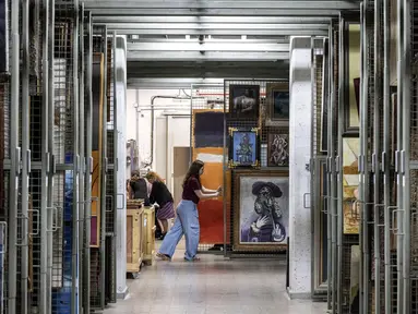 Nathalie Andrijasevic (kanan), asisten kurator di Museum Seni Tel Aviv, menangani lukisan-lukisan yang dipindahkan ke ruang aman bawah tanah karena konflik yang sedang berlangsung antara Israel dan Hamas serta ketegangan regional yang sedang berlangsung dengan Iran dan Hizbullah, di museum, di Tel Aviv, 13 Agustus 2024. (Oren ZIV / AFP)