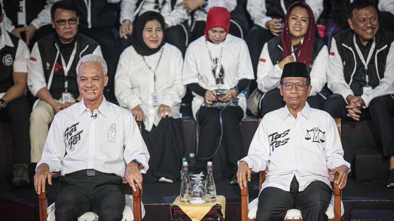 Ganjar Pranowo Tampil Beda di Debat Capres 2024, Kenakan Kemeja Putih Bertuliskan 'Sat Set'. Sementara Mahfud MD Bertuliskan 'Tes Tes' (Liputan6.com/Faizal Fanani)