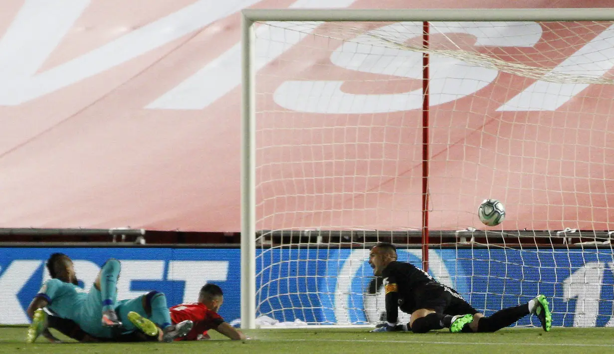 Pemain Barcelona Arturo Vidal (kiri) mencetak gol ke gawang Mallorca pada pertandingan La Liga di Son Moix Stadium, Palma de Mallorca, Spanyol, Sabtu (13/6/2020). Barcelona membantai Mallorca dengan skor 4-0. (AP Photo/Francisco Ubilla)