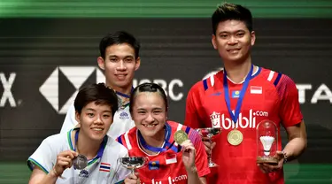 Pasangan Indonesia Praveen Jordan/Melati Daeva Oktavianti dan pasangan Thailand Dechapol Puavaranukroh/Sapsiree Taerattanachai memamerkan medali usai laga final ganda campuran All England 2020 di Birmingham, Inggris, Minggu (15/3/2020). Indonesia menang 21-15, 17-21, 21-8. (AP Photo/Rui Vieira)