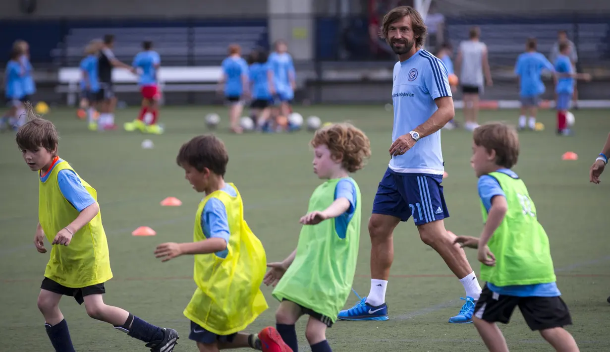 Andrea Pirlo saat bermain bola dengan pemain junior Major League Soccer (MLS) New York City FC di sebuah kamp di New York, AS (23/7/2015). Pirlo diboyong dengan gratis karena sudah tidak terikat kontrak dengan Juventus. (REUTERS/Mike Segar)